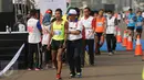Sejumlah pelari dievakuasi panitia usai lomba lari Jakarta Marathon 2015 di Silang Monas Jakarta, Minggu (25/10/2015). 15.000 pelari mengikuti lomba lari Jakarta Marathon 2015 yang terbagi dalam empat kategori utama. (Liputan6.com/Helmi Fithriansyah)