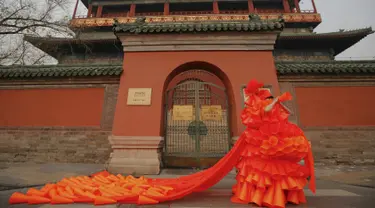 Seorang wanita bernama Kong Ning mengenakan kostum dari plastik berbentuk kerucut selama protes yang dilakukannya di Beijing, Cina, (7/12). Ini merupakan bagian protes terhadap polusi udara yang semakin parah di Cina. (REUTERS/Damir Sagolj)