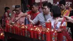 Warga keturunan Tionghoa menyalakan lilin saat bersembahyang Imlek 2569 di Vihara Dharma Bhakti, Petak Sembilan, Jakarta Barat, Jumat (16/2). Imlek 2569 jatuh pada shio anjing atau bisa disebut sebagai tahun anjing. (Liputan6.com/Arya Manggala)