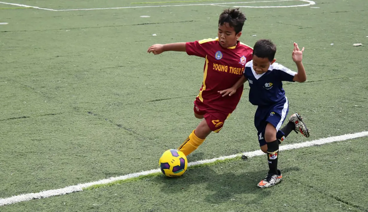 Kedua anak berebut bola saat berlaga pada Liga Bola Indonesia. Liga Bola Indonesia merupakan ajang pembinaan bagi para pesepak bola muda tanah air. (Bola.com/Vitalis Yogi Trisna)