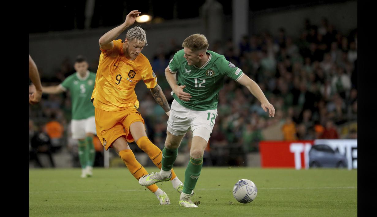 Pemain Timnas Belanda, Wout Weghorst (kiri), berusaha melewati pemain Timnas Irlandia Nathan Collins, dalam pertandingan grup B Kualifikasi Euro 2024 yang berlangsung di Aviva Stadium, Dublin, Senin (11/9/2023) dini hari WIB. (AP/PA/Donall Farmer)