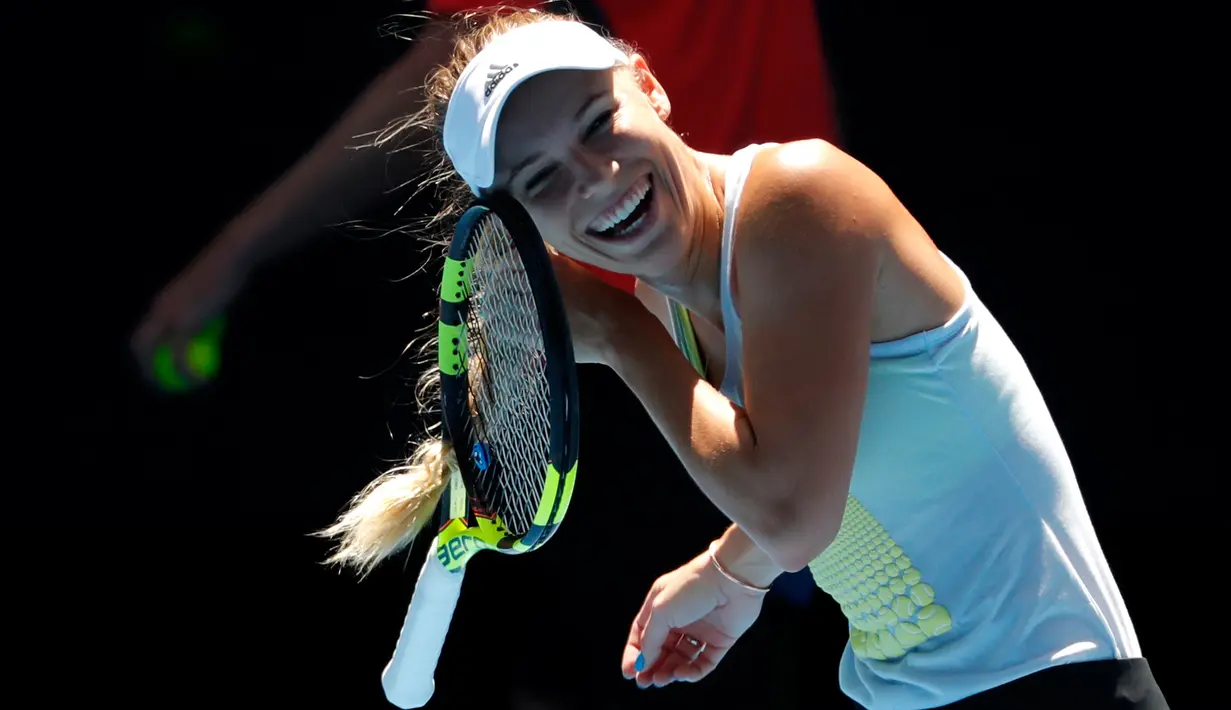 Petenis Denmark, Caroline Wozniacki berusaha melepas rambutnya yang tersangkut raket pada sesi latihan menjelang Grand Slam Australia Terbuka di Melbourne, Minggu (14/1). Grand slam tersebut bakal berlangsung 15-28 Januari 2018. (AP/Vincent Thian)