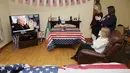 Veronica McKevitt (duduk), sepupu jauh Presiden terpilih Joe Biden, dan putri-putrinya Andrea McKevitt, dan Ciara bertepuk tangan di rumah mereka saat menyaksikan pelantikan Joe Biden di Louth, Irlandia  (20/1/2021). Joe Biden akan didampingi Wakil Presiden Kamala Harris. (Brian Lawless/PA via AP)