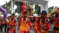 Warga menampilkan tarian Sisingaan Subang saat melakukan karnaval di jalan Pintu 1 Senayan, Jakarta, Minggu (24/9). Karnaval tersebut dilakukan dalam rangka HUT Gelora Bungkarno yang ke-55. (Liputan6.com/Angga Yuniar)