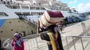 Seorang calon penumpang memakul barang bawaanya di Pelabuhan Penumpang Tanjung Priok, Jakarta, Kamis (30/6). Hal ini disebabkan semakin tingginya minat pemudik yang memilih menggunakan jasa pesawat terbang. (Liputan6.com/Faizal Fanani)