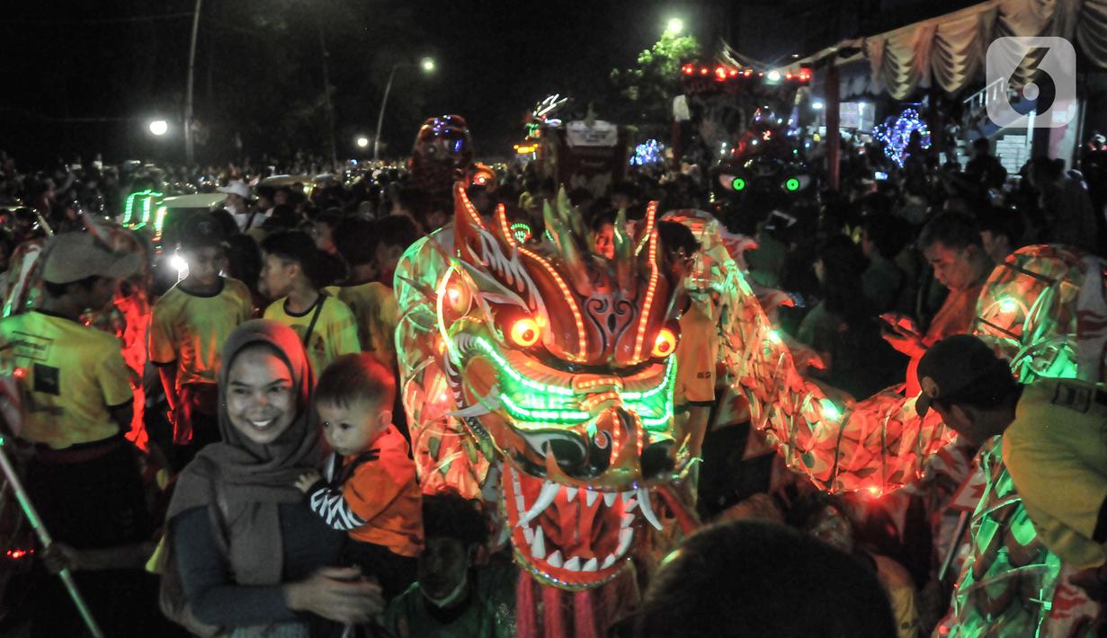 Warga menyaksikan pawai Liong dan Barongsai saat perayaan Cap Go Meh di Jalan Surya Kencana, Bogor, Jawa Barat, Minggu (5/2/2023). Pemkot Bogor kembali menggelar perayaan Cap Go Meh setelah 3 tahun ditiadakan akibat pandemi Covid-19. (merdeka.com/Iqbal S Nugroho)