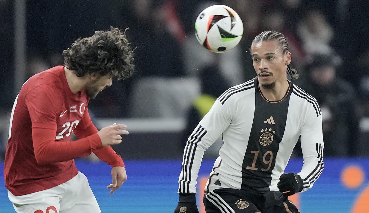 Bek Timnas Turki, Ferdi Kadioglu (kiri) berebut bola dengan gelandang Timnas Jerman, Leroy Sane pada laga uji coba internasional di Olympiastadion, Berlin, Minggu (19/11/2023) dini hari WIB. (AP Photo/Markus Schreiber)