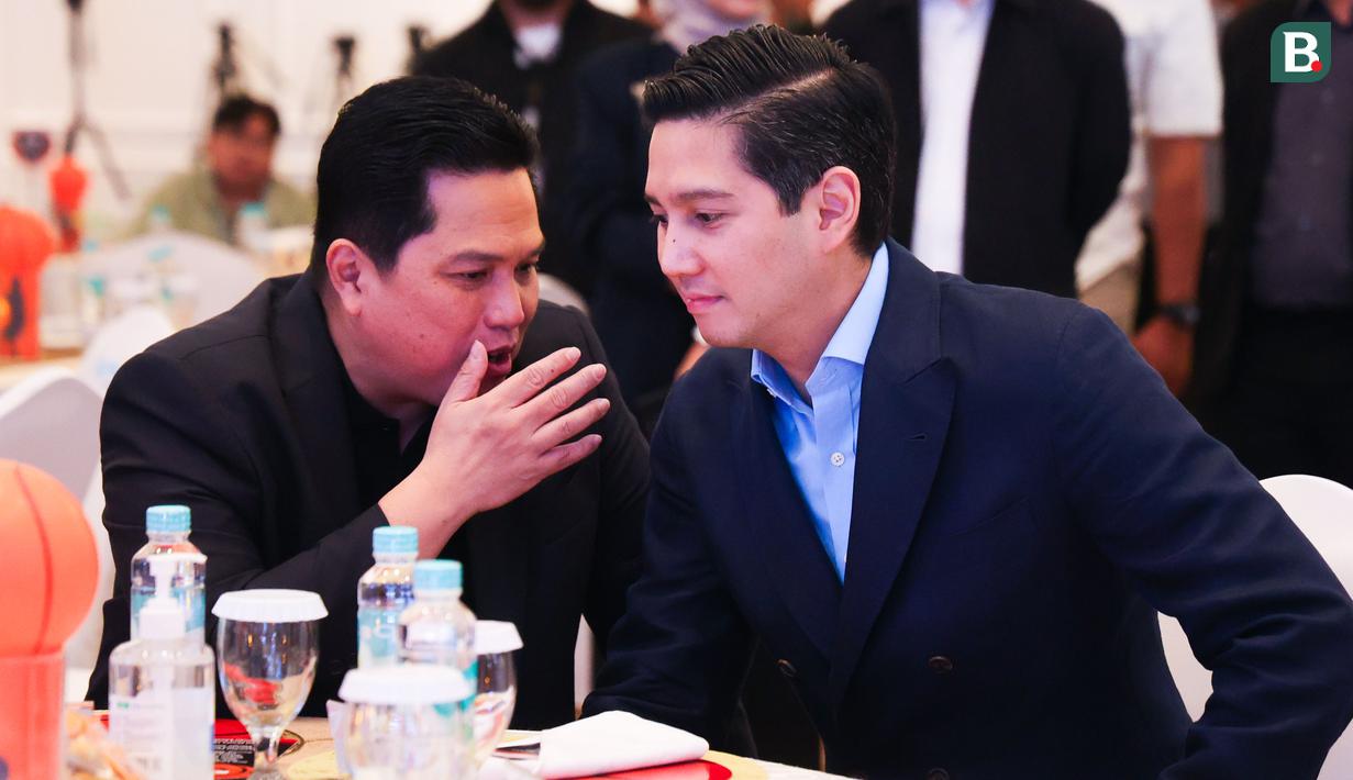 Menteri BUMN, Erick Thohir, berbincang dengan Direktur Utama Ketua Perbasi, Budisatrio Djiwandono, saat peresmian kerja sama antara Bank Mandiri dengan IBL di Plaza Mandiri, Jakarta, Selasa (1/7/2025). (Bola.com/Abdul Aziz)