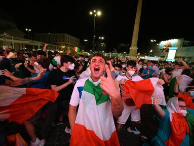 Fans bereaksi setelah timnas Italia mencetak gol kedua saat mereka menonton di layar raksasa dari zona penggemar resmi di Piazza del Popolo di Roma pada laga pertama grup A Euro 2020 /2021, Jumat (11/6/2021). Timnas Italia berhasil menang 3-0 atas Turki. (ANDREAS SOLARO/AFP)