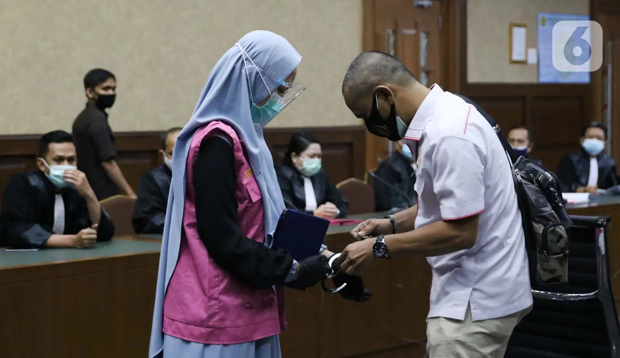 Tersangka dugaan korupsi dan tindak pidana pencucian uang terkait kepengurusan fatwa untuk Djoko Tjandra di Mahkamah Agung, Pinangki Sirna Malasari (kiri) bersiap menjalani sidang di Pengadilan Tipikor Jakarta, Rabu (30/9/2020). Sidang beragenda pembacaan eksepsi. (Liputan6.com/Helmi Fithriansyah)