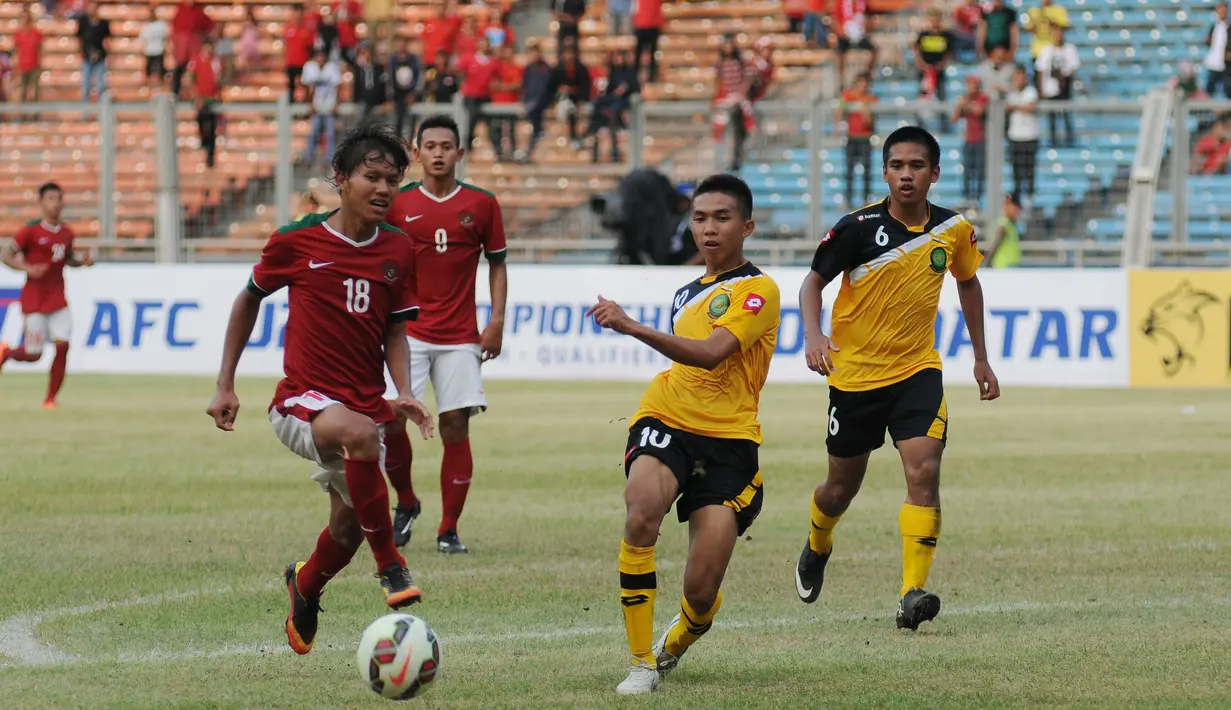 Pemain tengah timnas Indonesia U-23, Adam Alis (18) berusaha mengecoh pemain Brunei Darussalam, M Nur Ikhmal Bin Damit (kedua kanan) di laga kualifikasi grup H Piala Asia 2016 di Stadion GBK Jakarta, Minggu (29/3/2015). (Liputan6.com/Helmi Fithriansyah)