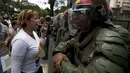 Polisi berjaga-jaga saat aksi menolak keputusan Mahkamah Agung  yang mencabut kekuasaan dari Majelis Nasional di Caracas, Venezuela, Sabtu (1/4). MA akhirnya membatalkan putusannya untuk memakzulkan kongres. (AP Photo / Fernando Llano)