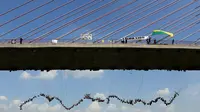 Ratusan orang melompat menggunakan tali dari jembatan yang memiliki ketinggian 30 meter di Hortolandia, Brasil, Minggu (10/4). Sebanyak 149 orang mencoba membuat rekor dunia dengan melompat bersama dari atas jembatan. (REUTERS/Paulo Whitaker)
