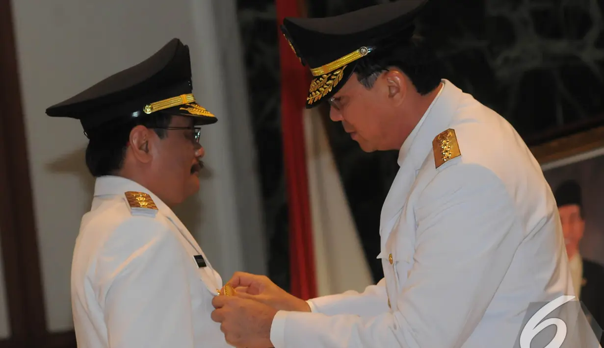 Gubernur DKI Jakarta Basuki Tjahaja Purnama atau Ahok menyematkan tanda jabatan pada Djarot Saiful Hidayat di pelantikan Wakil Gubernur DKI Jakarta, Jakarta, Rabu (17/12/2014). (Liputan6.com/Herman Zakharia)