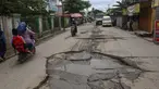 Warga melewati jalan yang rusak parah di Jalan Raya Tanjung Pasir, Tangerang, Banten, Rabu (22/1/2025). (merdeka.com/Arie Basuki)
