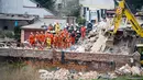 Petugas penyelamat mencari korban di reruntuhan sebuah apartemen tua yang ambruk di Swiebodzce, Polandia, Sabtu (8/4). Akibat insiden itu, 5 orang dikabarkan tewas, sementara 4 orang lainnya luka-luka, dan 1 orang hilang. (Natalia DOBRYSZYCKA/AFP)