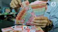 Petugas menata mata uang rupiah di salah satu gerai penukaran mata uang di Jakarta, Kamis (5/1/2023). Mengutip data Bloomberg pukul 15.00 WIB, rupiah ditutup turun 0,22 persen atau 34 poin ke Rp15.616,5 per dolar AS. Hal tersebut terjadi di tengah penguatan indeks dolar AS 0,16 persen ke 104,41. (Liputan6.com/Angga Yuniar)