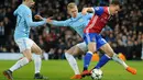 Dua pemain Manchester City berusaha merebut bola dari gelandang FC Basel Kevin Bua saat pertandingan Liga Champions leg kedua  di Stadion Etihad, Manchester (7/3). Manchester City menang agregat 5-2 atas FC Basel. (AP Photo / Rui Vieira)