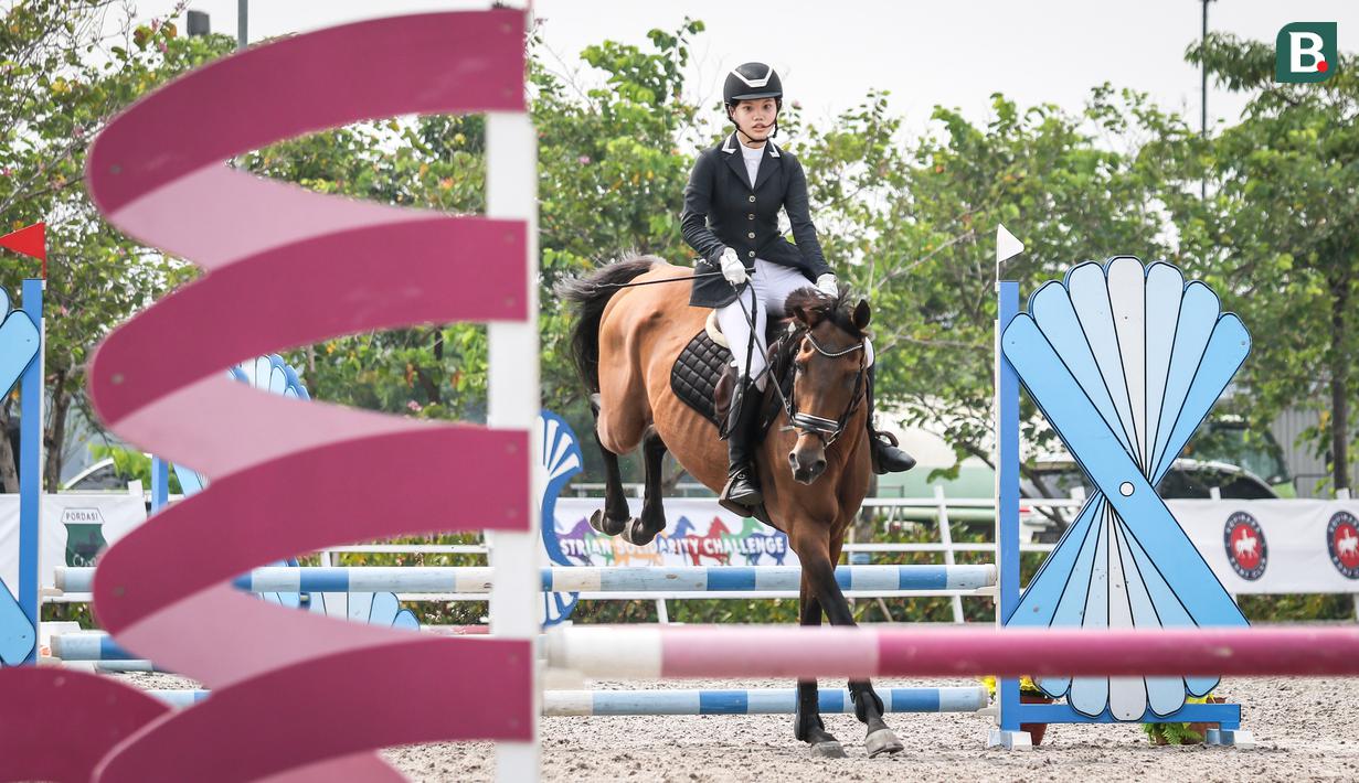 Atlet berkuda tim Djiugo, Natasya Indah Wijaya beraksi pada nomor Show Jumping 50-70 cm saat ajang Solidarity Equestrian Challange 2022 yang berlangsung di Jakarta International Equestrian Park, Jakarta Timur, Minggu (30/01/2022). (Bola.com/Bagaskara Lazuardi)