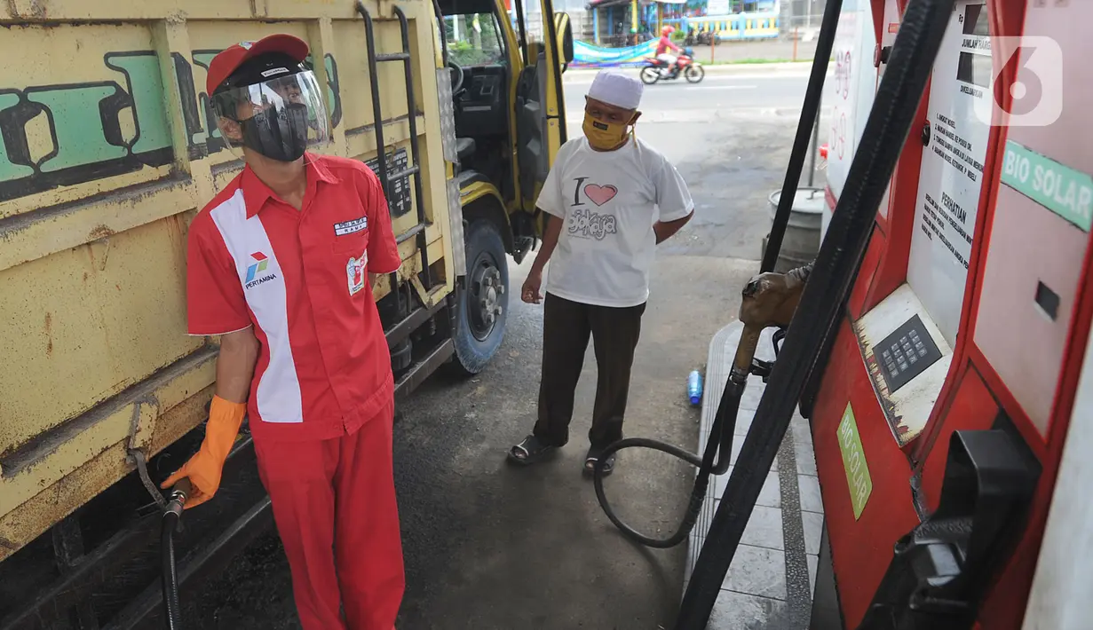 Petugas dengan sarung tangan, masker dan pelindung wajah melayani pembeli BBM di SPBU kawasan Cilendek, Bogor, Selasa (5/5/2020). Mencegah penularan Covid-19, sejumlah perusahaan memberikan pelindung diri kepada pegawai, terlebih yang berhubungan langsung dengan pelanggan. (merdeka.com/Arie Basuki)