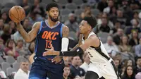 Forward Oklahoma City Thunder Paul George (kiri) dijaga penggawa San Antonio Spurs Dejounte Murray pada laga NBA 2017-2018 di AT&T Center, Kamis (29/3/2018) atau Jumat (30/3/2018) WIB. (AP Photo/Darren Abate)