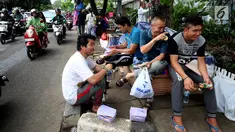 Para pencari suaka bercengkerama di trotoar depan Rumah Detensi Imigrasi Kalideres, Jakarta, Jumat (19/1). Selama 17 minggu, sebanyak 57 WNA tinggal di trotoar karena ruangan Rumah Detensi Imigrasi tersebut penuh. (Liputan6.com/JohanTallo)