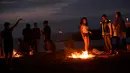 Sejumlah orang membakar barang-barang saat mengikuti tradisi malam San Juan's (Saint John) di Gijon, Spanyol, (24/6). Malam San Juan adalah upacara penyucian dimana warga membakar sejumlah benda yang sudah tidak diinginkan. (REUTERS/Eloy Alonso)
