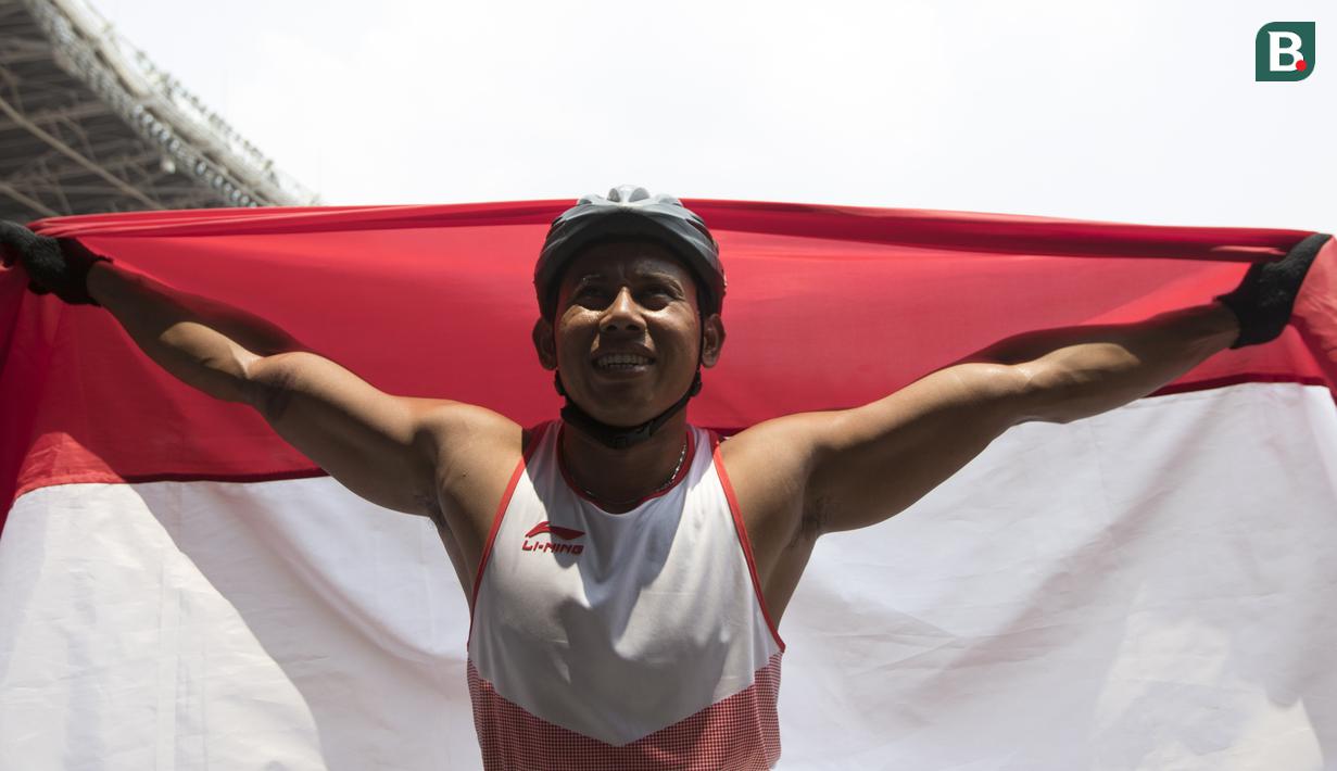 Pebalap kursi roda Indonesia, Jaenal Aripin, melakukan selebrasi usai meraih medali perak pada Asian Para Games cabang atletik nomor balap kursi roda 200 meter T 54 di SUGBK, Jakarta, Jumat (12/10). (Bola.com/Vitalis Yogi Trisna)