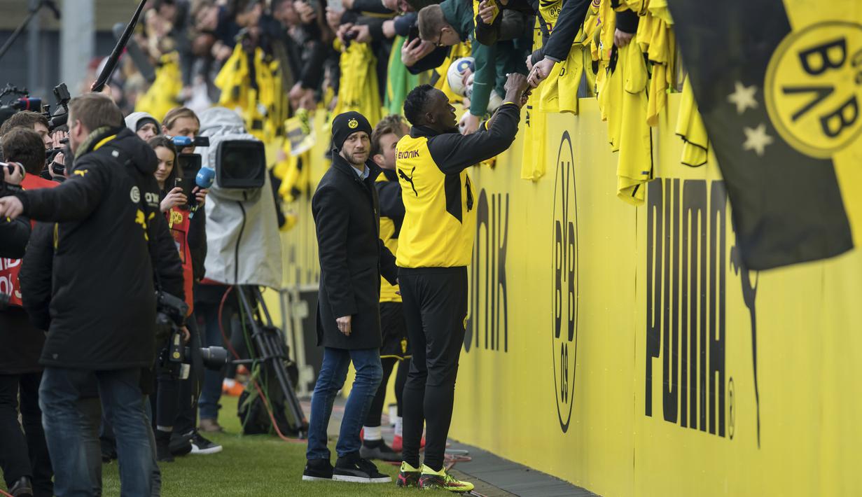 Usain Bolt memberikan tanda tangan kepada suporter usai berlatih bersama Borussia Dortmund di Dortmund, Jerman, (23/3/2018). Bolt pensiun dari dunia atletik usai Kejuaraan Dunia 2017.  (Guido Kirchner/dpa via AP)