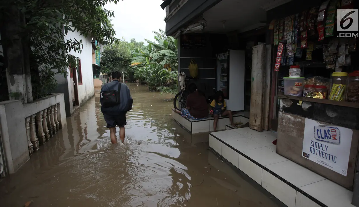 Warga beraktivitas saat banjir merendam kawasan Cipinang Melayu, Jakarta Timur, Senin (5/2). Genangan air terlihat memenuhi jalan di pemukiman warga. (Liputan6.com/Arya Manggala)