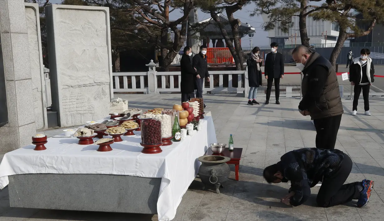 Anggota keluarga asal Korea Selatan membungkuk untuk menghormati leluhur mereka di Korea Utara, pada Tahun Baru Imlek di Paviliun Imjingak di Paju pada Jumat (12/2/2021). Perayaan Imlek di Korea Selatan meliputi pada reuni keluarga, makanan, dan mengenang leluhur. (AP Photo/Lee Jin-man)