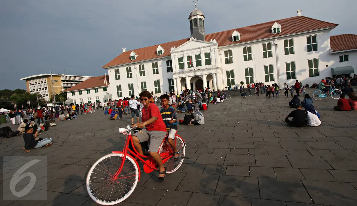 Warga berwisata menaiki sepeda kuno di kawasan Kota Tua, Jakarta, Minggu (8/5). Meskipun libur panjang akan berakhir, Warga tetap memadati kawasan wisata Kota Tua. (Liputan6.com/Immanuel Antonius)