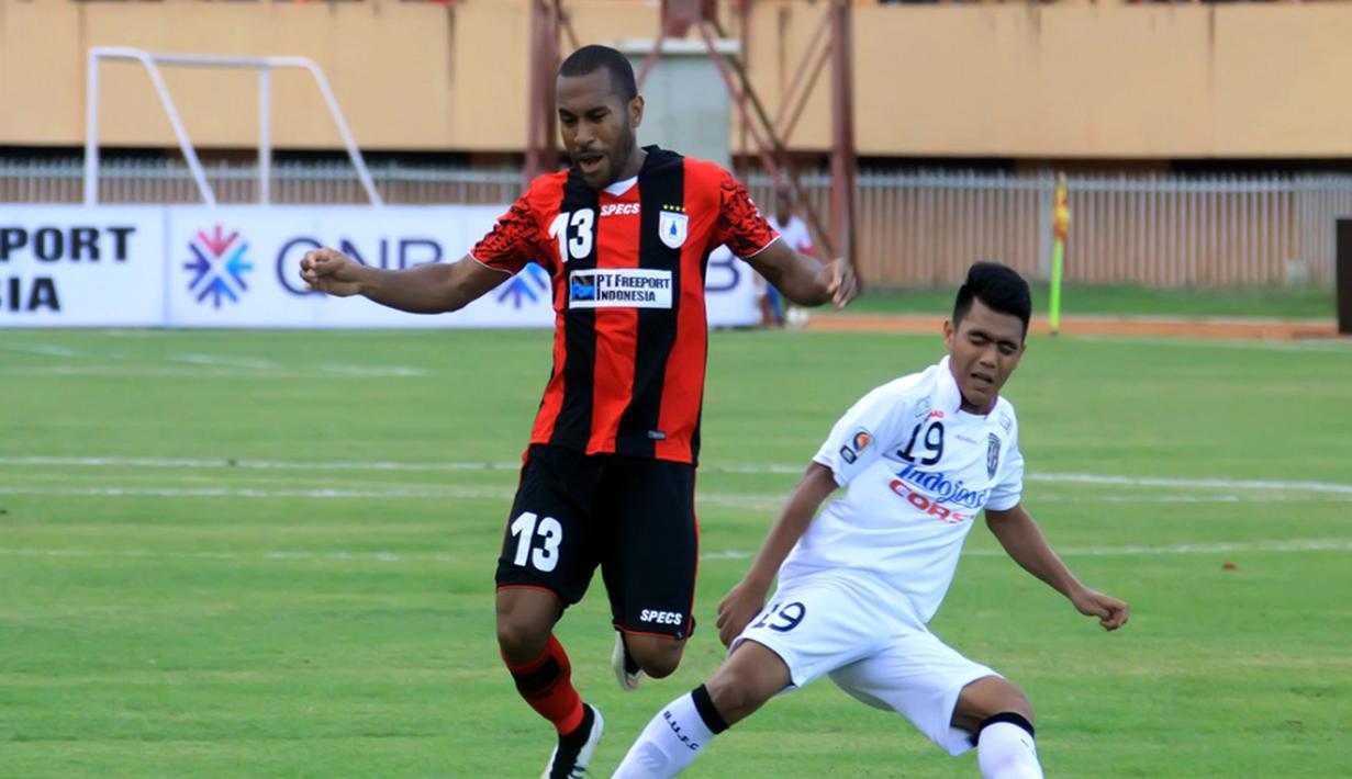 Gelandang Persipura Ian Kabes terbang setelah diterjang pemain Bali United Hendra Sandi. (Liga Indonesia)