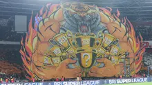 The Jakmania membentangkan koreografi raksasa Macan memeluk trofi saat laga Persija Jakarta  vs PSIM Yogyakarta pada laga pekan ke-14 BRI Super League 2025/2026 di Stadion Utama Gelora Bung Karno, Jakarta, Jumat (28/11/2025) malam. (Bola.com/M Iqbal Ichsan).