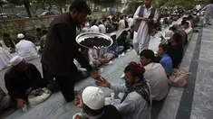 Salah satu petugas memberikan takjil kepada warga yang menunggu waktu berbuka puasa di kota Kabul, Afganistan, (29/6/2014). (REUTERS/Omar Sobhani)