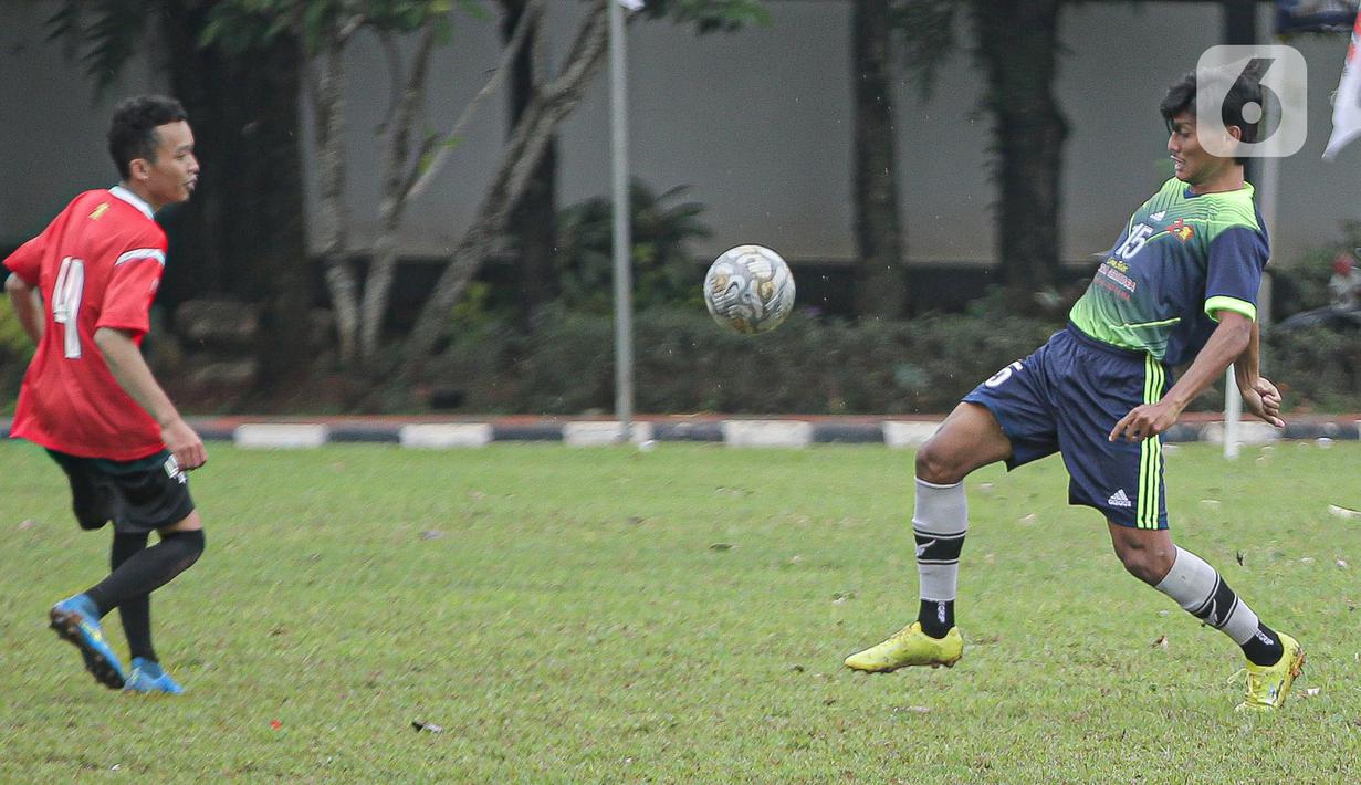 Pemain tim fraksi Gerinda berebut bola dengan pemain tim Gedung Taman DPR saat pertandingan dalam rangkaian HUT Gerindra ke-15 di Lapangan Sepak bola DPR RI, Jakarta, Selasa (31/1/2023). Sejumlah kegiatan dilaksanakan dalam rangkaian HUT Gerinda Ke-15 yang digelar sederhana dan tidak secara foya-foya. (Liputan6.com/Faizal Fanani)
