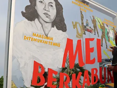 Seorang peserta aksi yang tergabung dalam Jaringan Solidaritas Korban untuk Keadilan (JSKK)  membuat mural saat aksi kamisan ke-493 di depan Istana Negara, Jakarta, Kamis (18/5). (Liputan6.com/Immanuel Antonius)