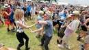 Sejumlah penonton berdansa menikmati musik selama New Orleans Jazz and Heritage Festival di Fair Grounds di New Orleans , AS (25/4). (Ted Jackson / NOLA.com Times-Picayune via AP)