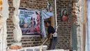 Seorang pria membersihkan puing-puing rumah yang rusak akibat gempa di Lembor, provinsi Nusa Tenggara Timur, Indonesia, Minggu, 16 Agustus 2026. (AP Photo/Firdia Lisnawati)