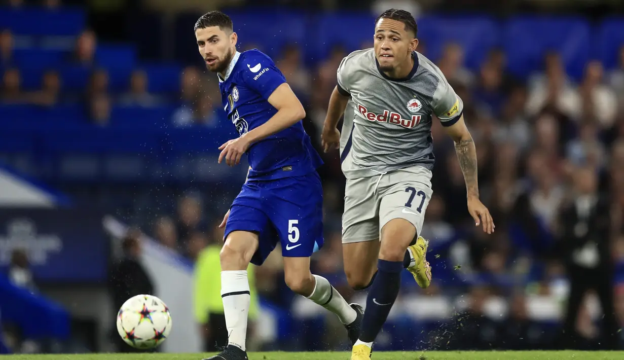 Gelandang  Chelsea Jorginho mengoper bola saat penyerang Red Bull Salzburg Noah Okafor berlari dalam matchday Grup E Liga Champions di Stamford Bridge, Kamis (15/9/2022) dini hari WIB. Chelsea hanya mampu bermain imbang 1-1 dengan RB Salzburg. (AP Photo/Leila Coker)