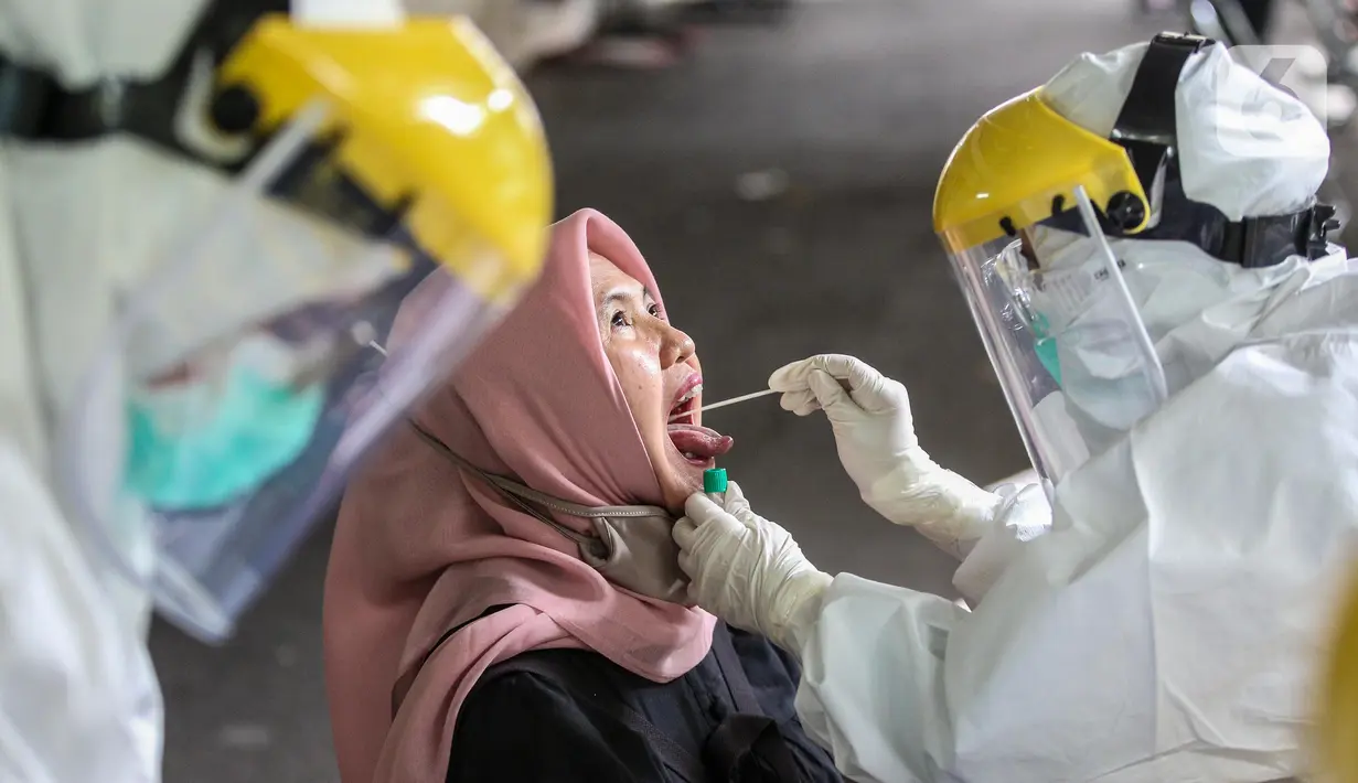 Petugas Puskesmas Kecamatan Gambir mengambil sampel lendir saat tes usap (Swab Test) COVID 19 di kawasan jalan Juanda, Jakarta, Selasa (16/6/2020).  Tes Swab untuk mencari warga positif Covid-19 tanpa gejala ini menyasar petugas PPSU dan para pedagang Pasar Ceylon. (Liputan6.com/Faizal Fanani)