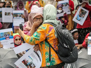 Dua pekerja rumah tangga (PRT) berpelukan saat menggelar aksi di depan Taman Aspirasi Monas, Jakarta, Rabu (21/12/2022). Aksi tersebut dilakukan untuk memperingati Hari Ibu serta meminta pemerintah untuk mengesahkan Rancangan Undang-Undang Perlindungan Pekerja Rumah Tangga (RUU PPRT). (Liputan6.com/Faizal Fanani)