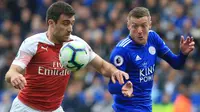 Striker Leicester City, Jamie Vardy, berebut bola dengan bek Arsenal, Sokratis Papastathopoulos, pada laga Premier League di Stadion King Power, Minggu (28/4). Leicester City menang 3-0 atas Arsenal. (AFP/Lindsey Parnaby)