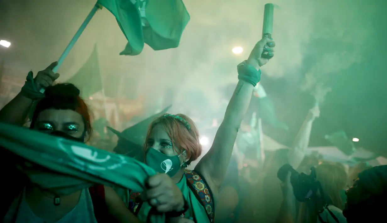 Aktivis hak-hak aborsi merayakan setelah anggota parlemen menyetujui undang-undang yang melegalkan aborsi di luar Kongres, Buenos Aires, Argentina, Rabu (30/12/2020). Ini merupakan puncak bagi para aktivis perempuan setelah bertahun-tahun lamanya. (AP Photo/Natacha Pisarenko)