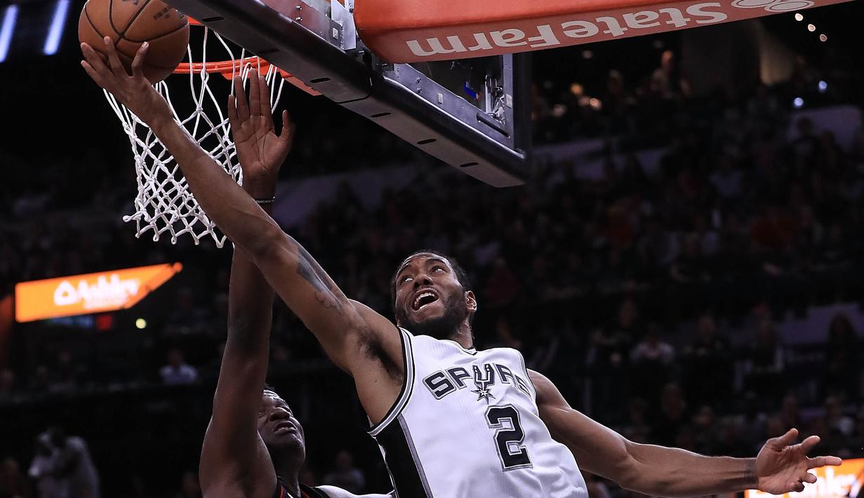 Pebasket San Antonio, Kawhi Leonard, melewati hadangan pebasket Houston Rockets, Clint Capela, pada laga semifinal wilayah barat NBA di AT&T Center, San Antonio, Rabu (3/5/2017). Spurs menang 121-96 atas Rockets. (AFP/Ronald Martinez)
