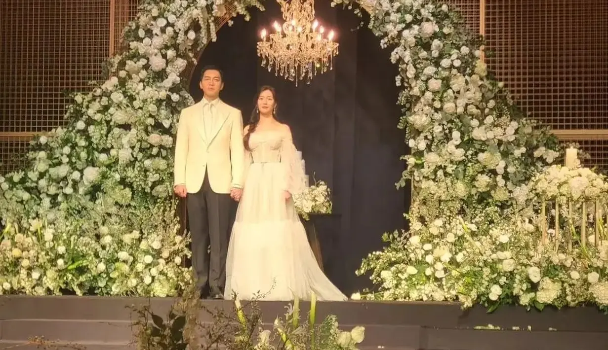 Lee Seung Gi sendiri berganti blazer putih. Masih dengan kemeja putih, dasinya berganti dengan dasi panjang putih, dipadu dengan celana panjang hitam. Foto: Instagram.