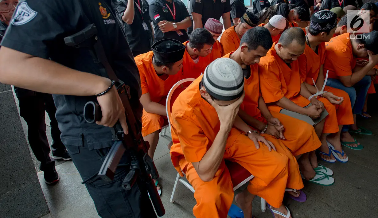 Tersangka tertunduk saat dihadirkan dalam rilis kasus narkoba jaringan Malaysia-Indonesia di Bareskrim Mabes Polri, Jakarta, Selasa (9/7/2019). Bareskrim Polri memusnahkan 177,5 Kg sabu dan 30 ribu butir ekstasi yang disita dari jaringan Malaysia-Indonesia. (merdeka.com/Imam Buhori)