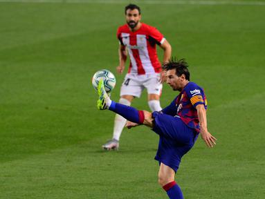 Penyerang Barcelona, Lionel Messi berusaha mengontrol bola saat bertanding melawan Athletic Bilbao pada lanjutan La Liga Spanyol  di stadion Camp Nou, Barcelona (23/6/2020). Barcelona menang tipis atas Bilbao 1-0 berkat gol tunggal Ivan Rakitic. (AFP/Pau Barrena)