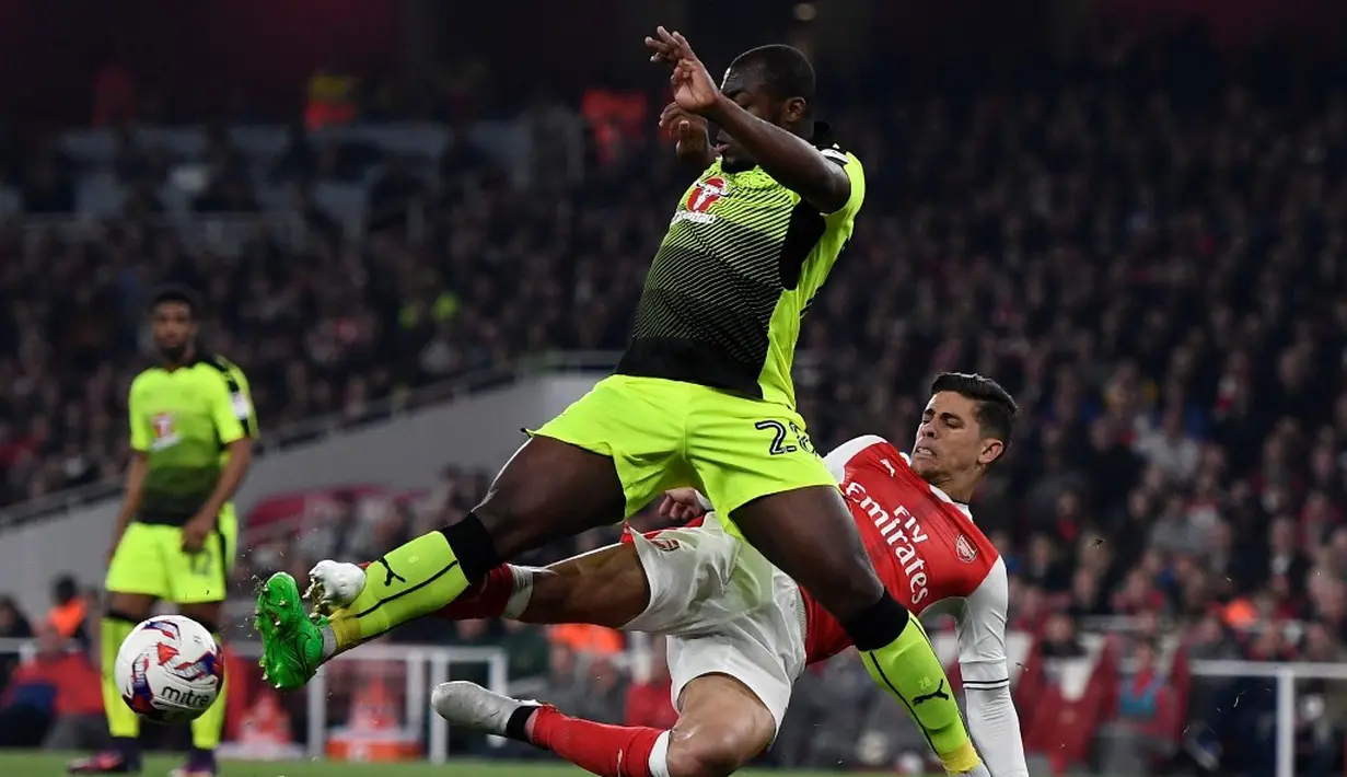 Pemain Arsenal,  Gabriel Paulista, berebut bola dengan pemain Reading, Danzell Gravenberch, dalam laga 16 besar Piala Liga Inggris di Stadion Emirates, Rabu (26/10/2016) dini hari WIB. (Reuters/Dylan Martinez)