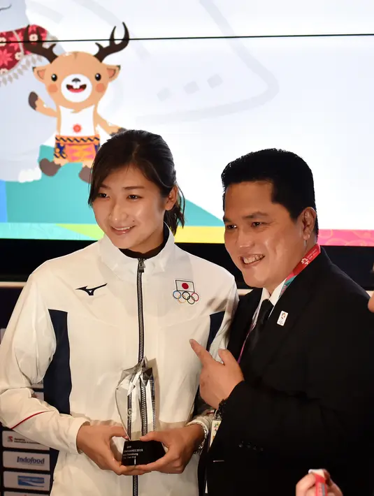 Perenang Jepang, Rikako Ikee berpose dengan Ketua Inasgoc Erick Thohir saat dinobatkan sebagai Most Valuable Player (MVP) Asian Games 2018 di Jakarta, Minggu (2/9). Rikako meraih enam medali emas dan dua perak di Asian Games 2018. (Juni Kriswanto/AFP)